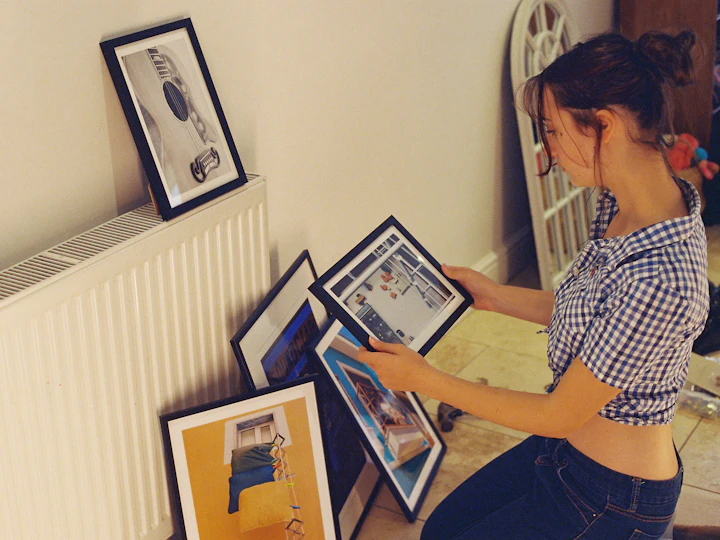A woman choosing between framed prints