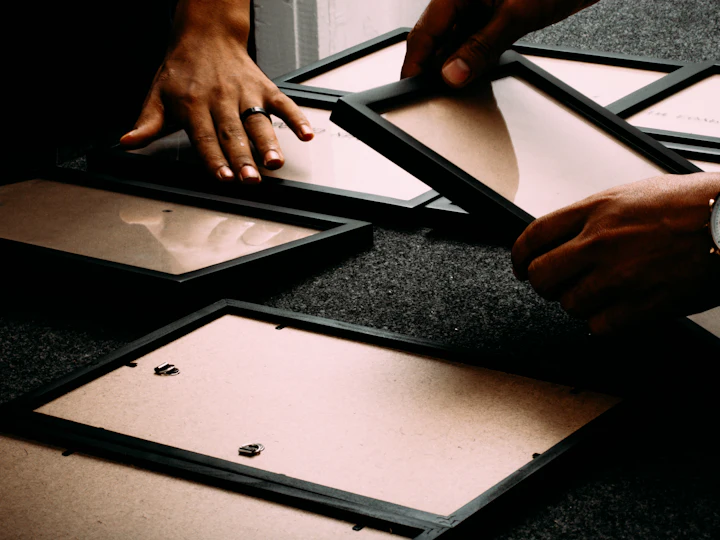 Hands assembling picture frames on a work table