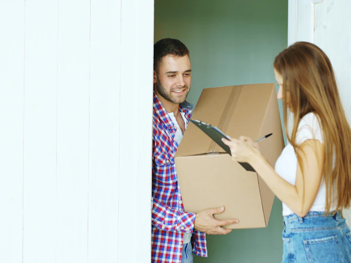 A delivery person handing a box to a customer at the door